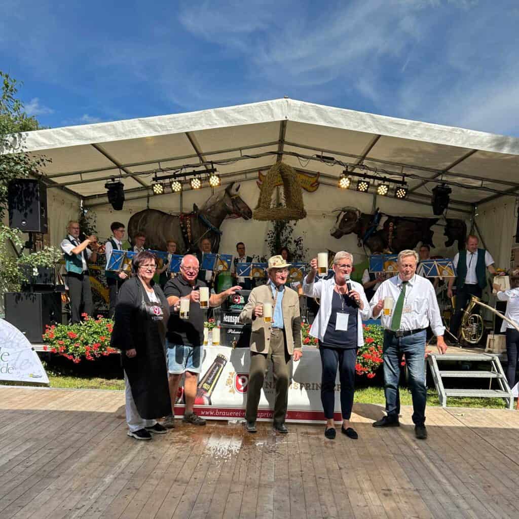 Eine Gruppe von Menschen vor einem Festzelt beim Festbieranstich